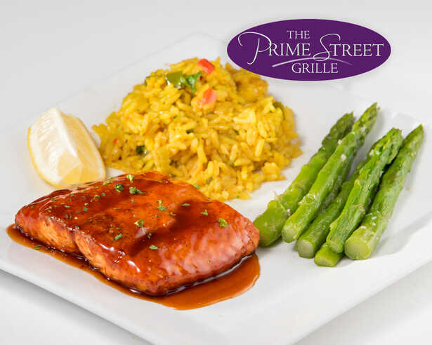 Salmon served with rice and asparagus at The Prime Street Grille